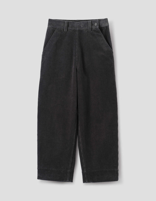 Dark grey cotton corduroy trousers, with offset button fastening waistband, flat front side opening, slanted pocket and deep hem. Front flat lay view.