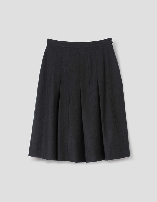 Black wool skirt with dark grey stripes, pleats, narrow horn button-through waistband and side zip fly. Front flat lay view.