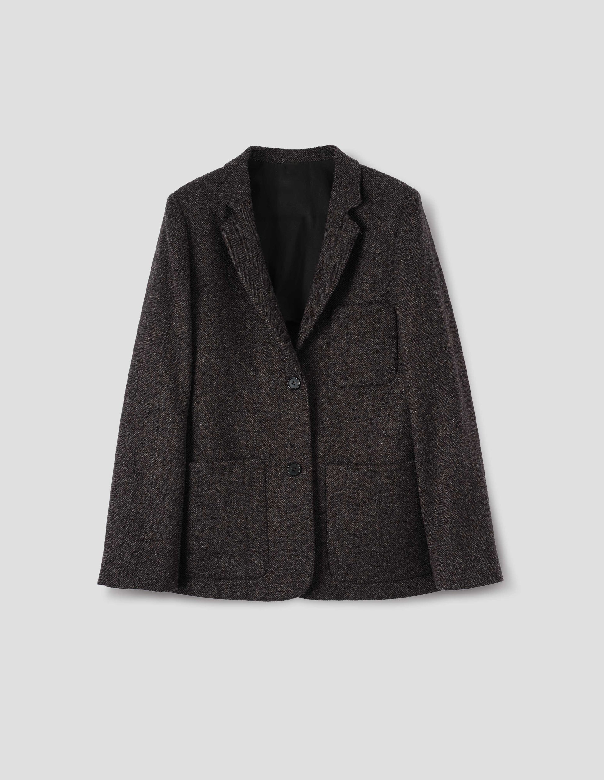 Brown and black herringbone wool blazer with narrow collar and horn button-through revere, three bluff patch pockets, rounded details on hem and pockets. Front flat lay view.