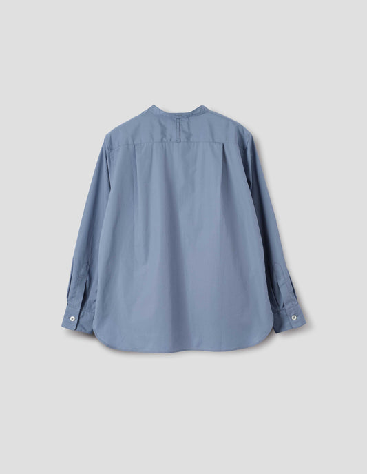 Blue cotton poplin collarless shirt with narrow shoulder yoke with hanger loop, curved stepped hem and mother of pearl buttons on cuffs. Back flat lay view.