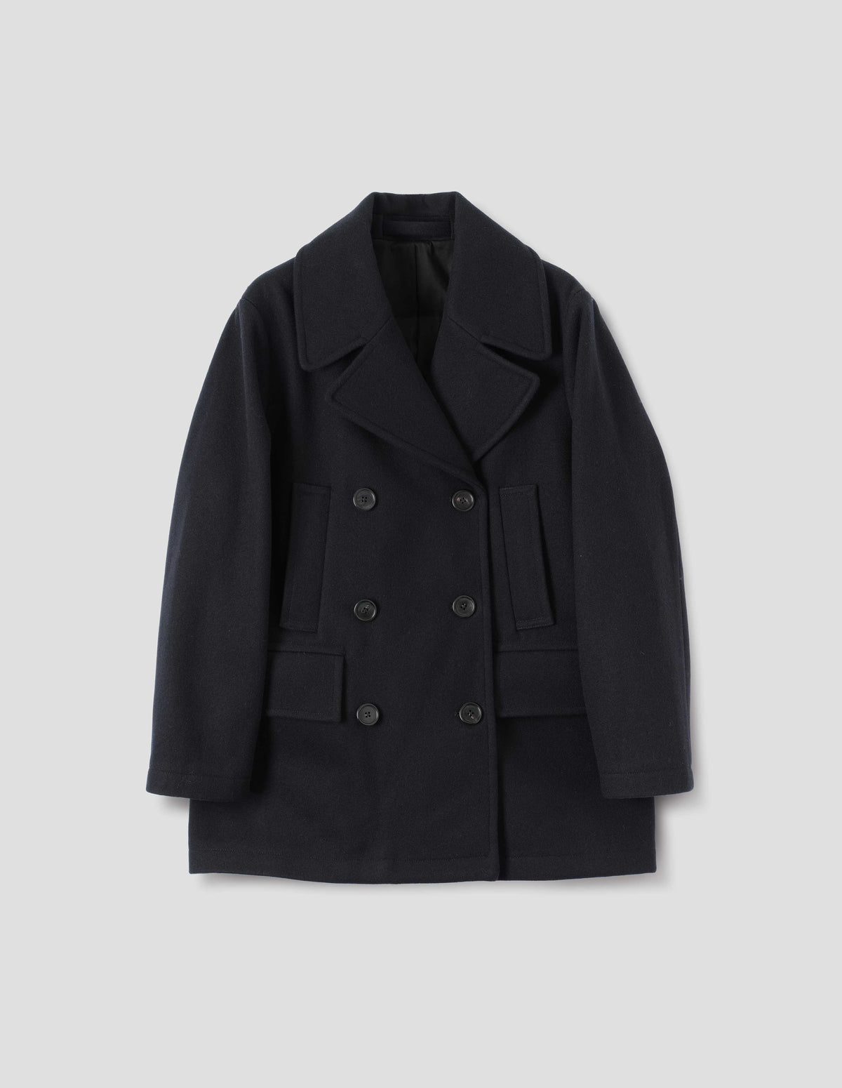 Dark blue wool coat with large collar and revere, double breasted front with horn buttons, high-set single welt pockets and large flap pockets. Front flat lay view.