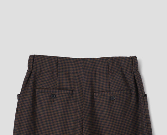 Dark blue and dark brown linen wool gingham trousers with elasticated waistband and horn button-through jet back pockets. Back flat lay view.
