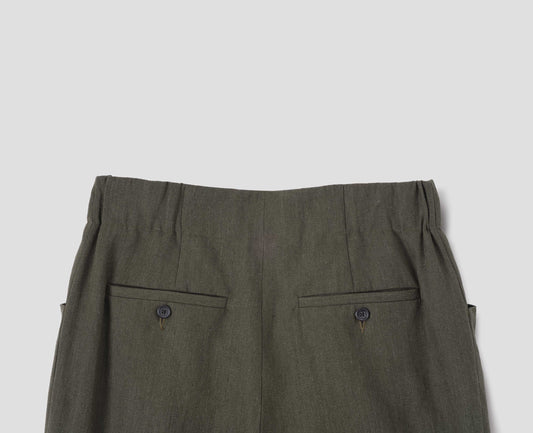 Dark green linen trousers with elasticated waistband and horn button-through jet back pockets. Back flat lay view.