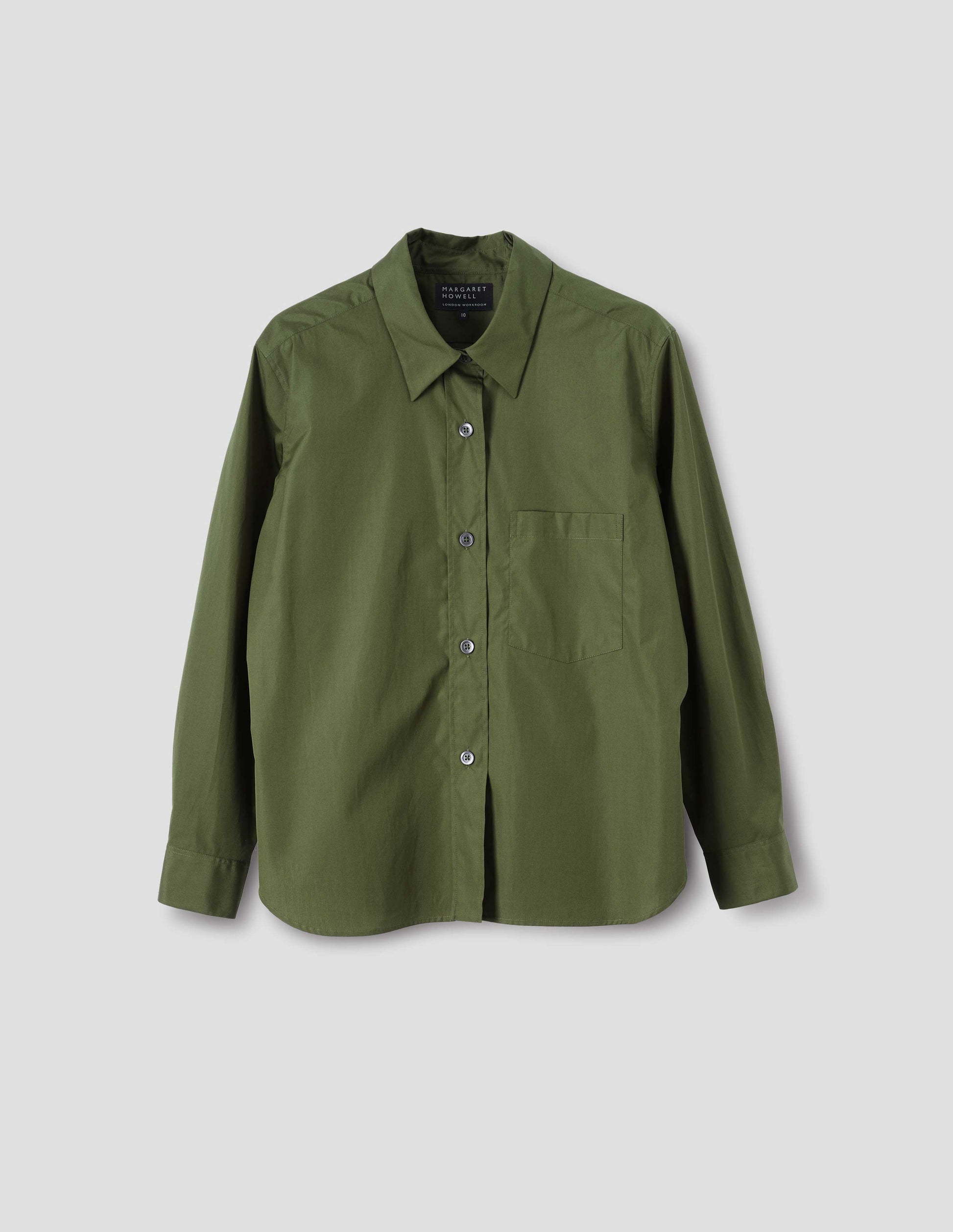 Green cotton shirt with mother of pearl buttons on raised placket, chest patch pocket and curved hem. Front flat lay view.