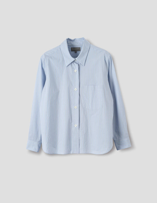 Light blue cotton shirt with grey and beige stripes, mother of pearl buttons on raised placket, dropped patch pocket and curved hem. Front flat lay view.