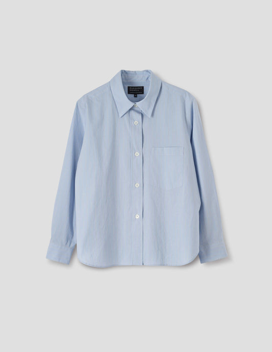 Light blue cotton shirt with grey and beige stripes, mother of pearl buttons on raised placket, chest patch pocket and curved hem. Front flat lay view.