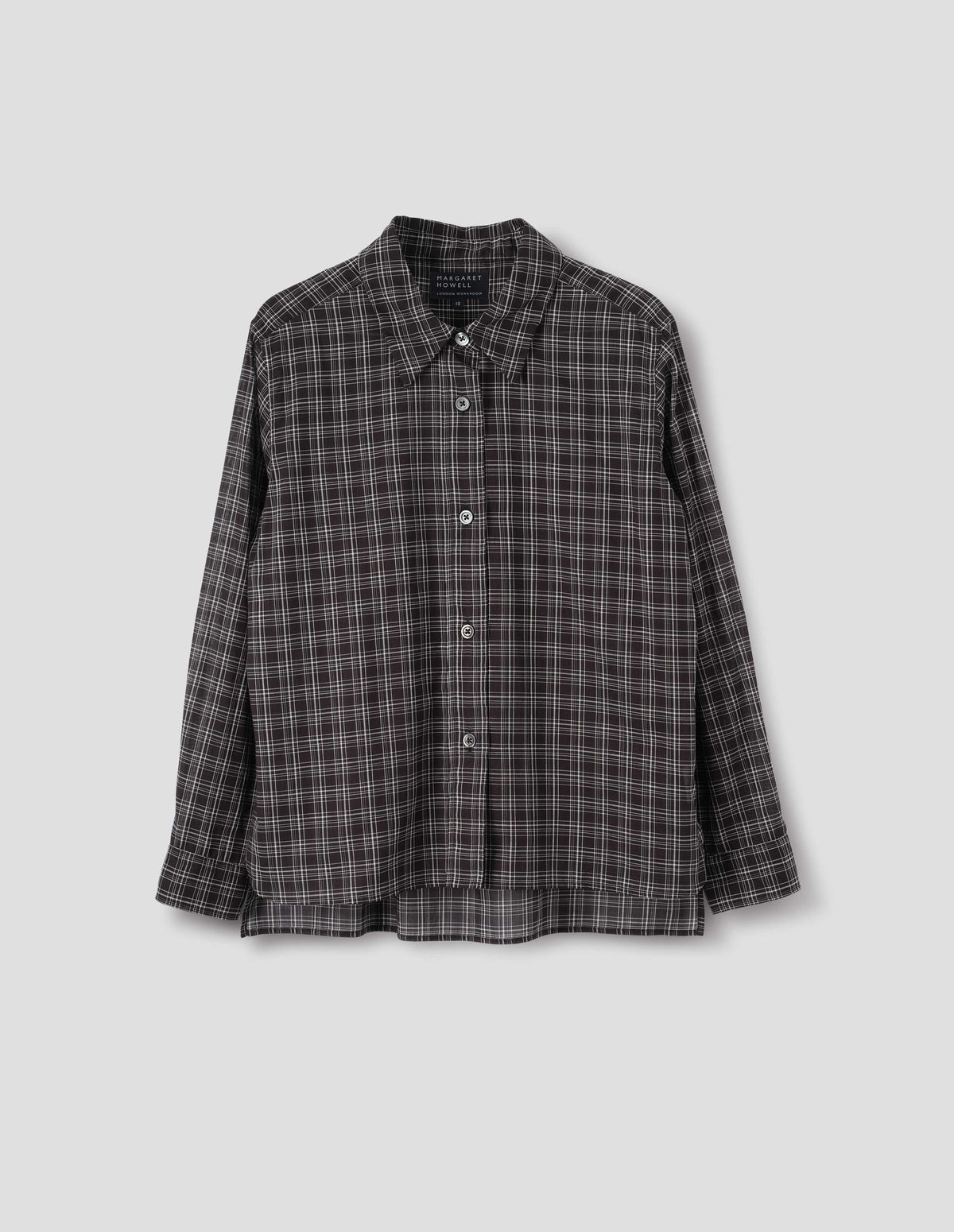 Black and white cotton check shirt with mother of pearl buttons on placket, stepped hem with curved front and straight-cut back. Front flat lay view.