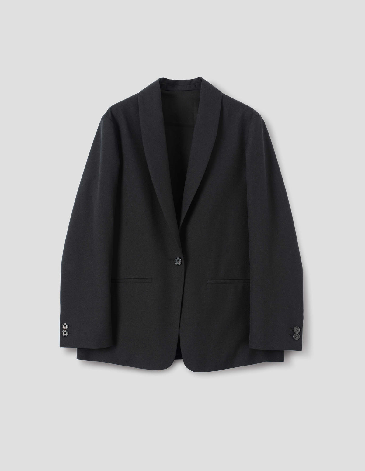 Black wool blazer with same fabric lapel, single horn button fastening, horn button-through cuffs and slanted welt pockets. Front flat lay view.