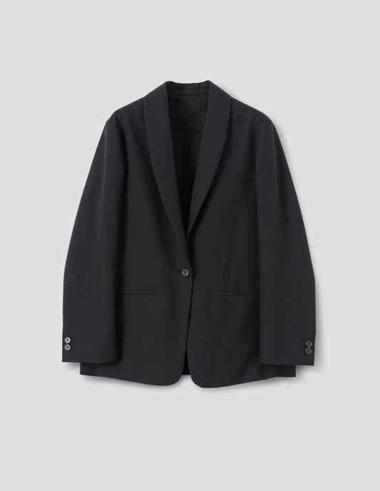 Black wool blazer with same fabric lapel, single horn button fastening, horn button-through cuffs and slanted welt pockets. Front flat lay view.