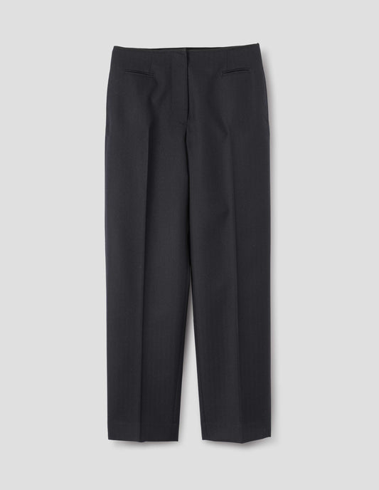 Dark blue wool trousers with cotton fine-binding waistband, zip fly with hook and bar fastening, small front welt pockets and side pockets. Front flat lay view.