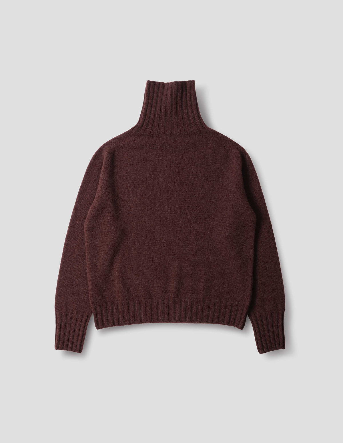 Dark red seamless cashmere roll neck jumper with contrast ribbing on neck, cuffs and hem. Back flat lay view.
