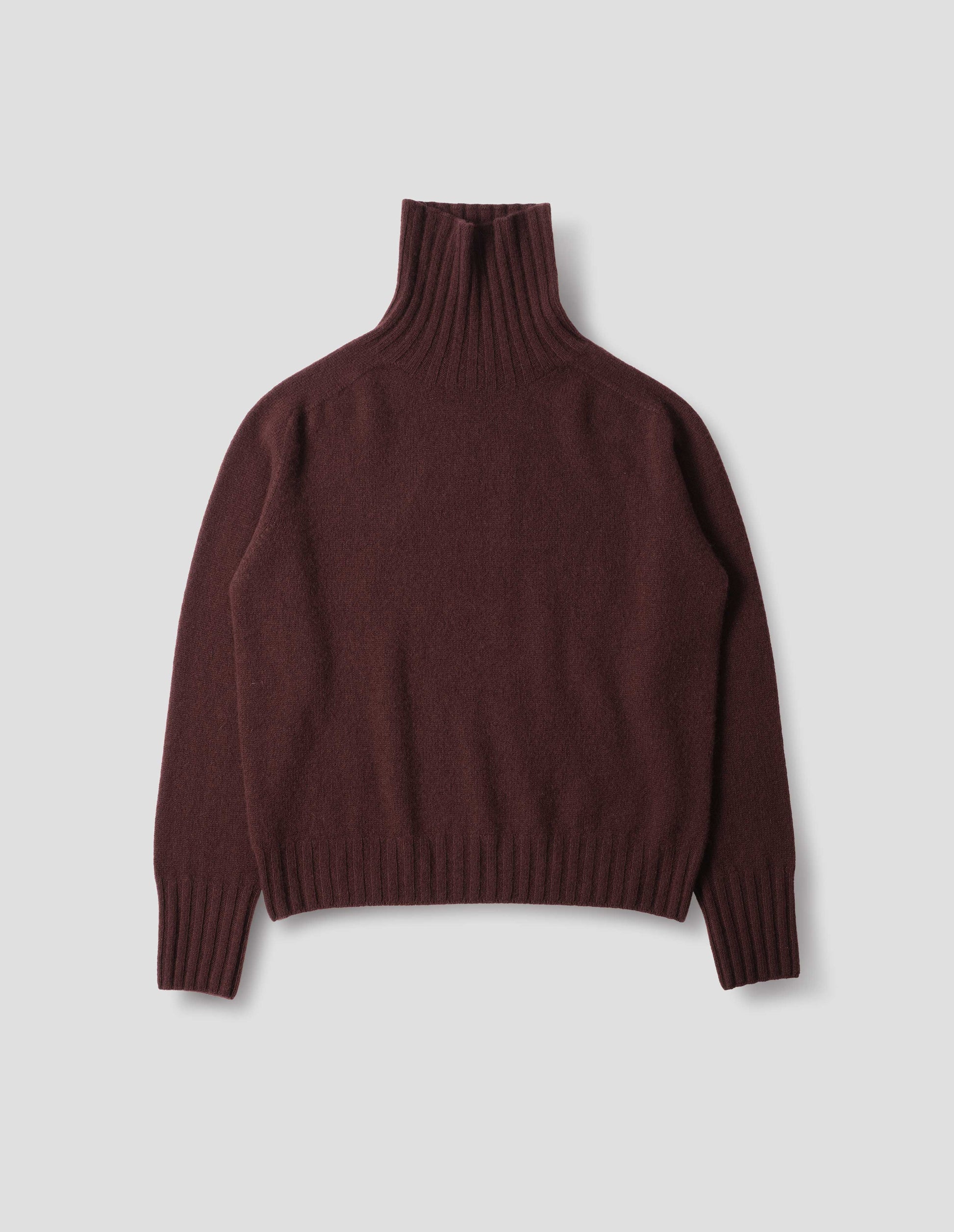 Dark red seamless cashmere roll neck jumper with contrast ribbing on neck, cuffs and hem. Front flat lay view.