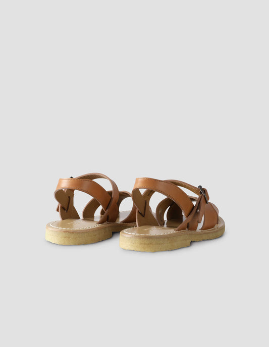 A pair of tan leather sandals with roller buckle fastening, contrast leather sole lining and crepe soles. Back flat lay view.