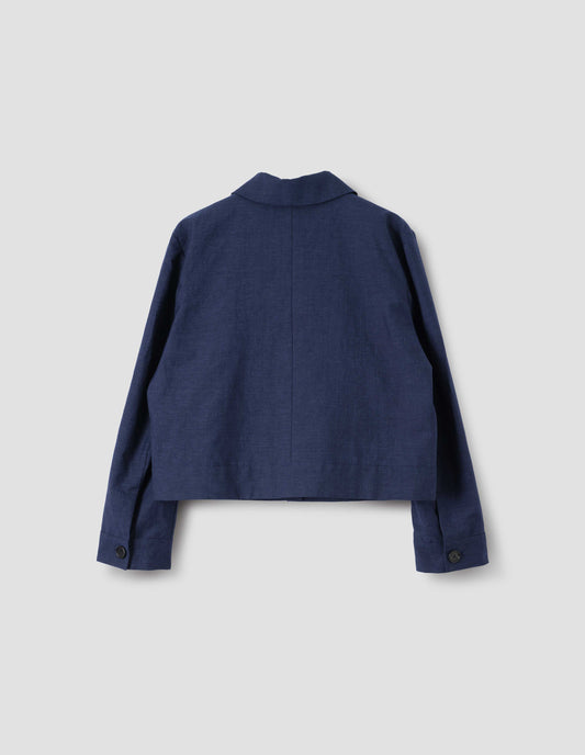 Navy blue cropped utility jacket with horn button cuffs, back flat lay view.