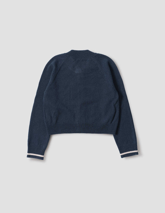 Blue cropped length cardigan with raglan sleeve and contrast stripe on cuff, back flat lay view