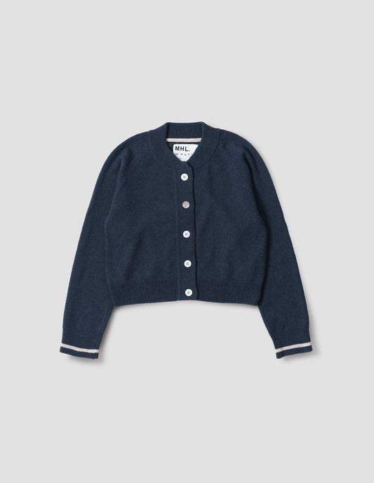 Blue cropped length cardigan with raglan sleeve, white corozo brace button fastening, contrast stripe on cuffs, front flat lay view.
