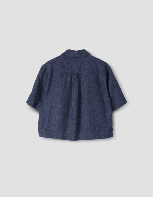 Indigo blue cropped short sleeve shirt, with box pleat and hanger loop detail on back yoke, back flat lay view.