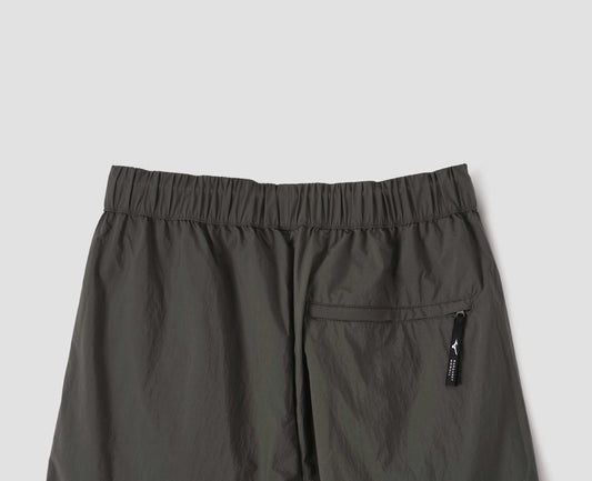 Dark green trousers with zip welt back pocket and elasticated waist, back flat lay view.