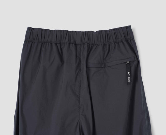 Dark blue trousers with zip welt back pocket and elasticated waist, back flat lay view.