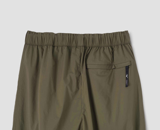 Green trousers with zip welt back pocket and elasticated waist, back flat lay view.