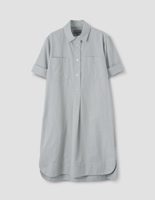 Light grey shirt dress with short sleeves, chest pockets and black mother of pearl buttons, front flat lay view.