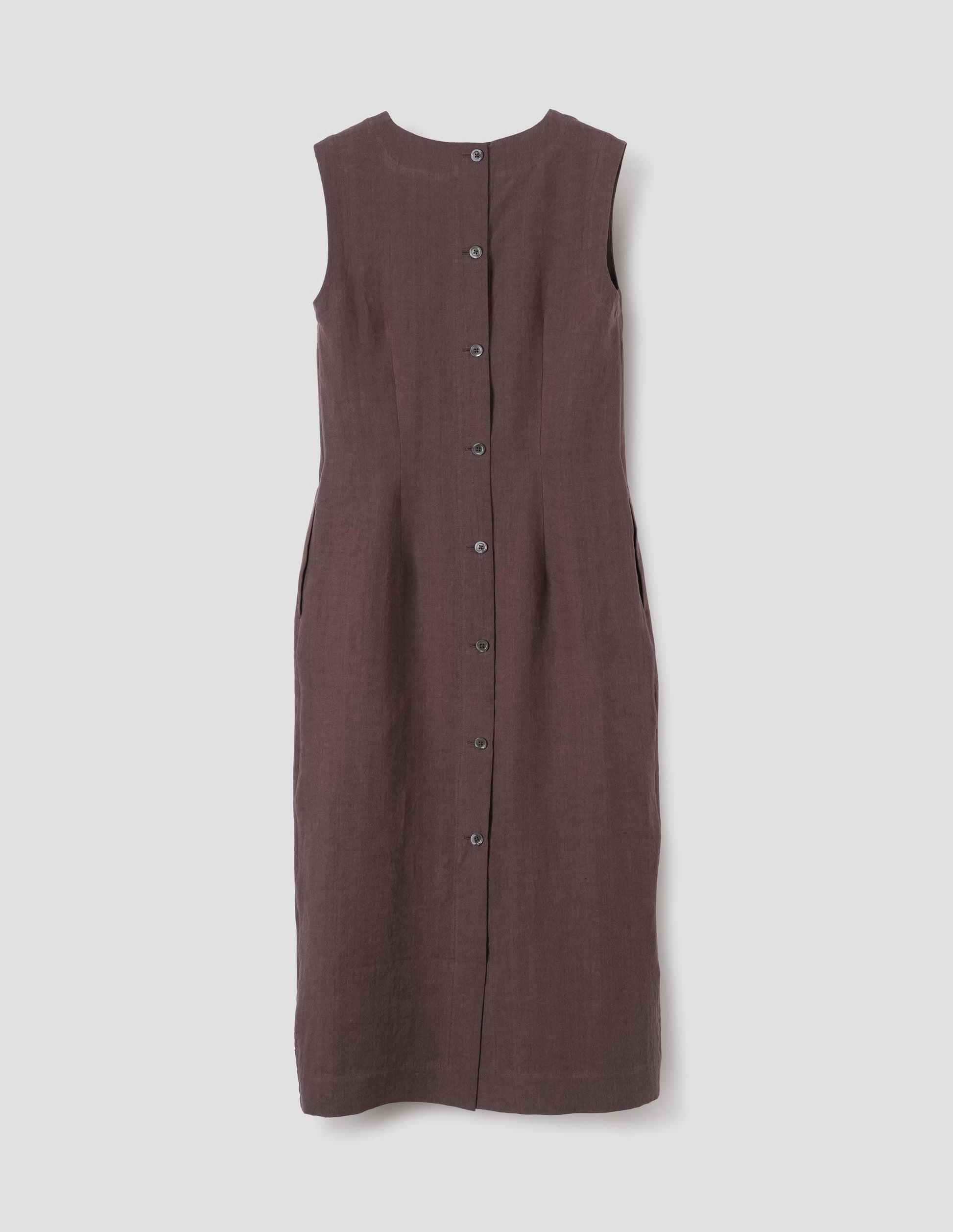 Brown midi-length sleeveless dress with concealed side pockets, mother of pearl buttons and back vent. Back flat lay view.