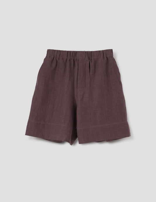 Reddish brown linen shorts, with elasticated waistband, side entry pockets and deep hem. Front flat lay view.