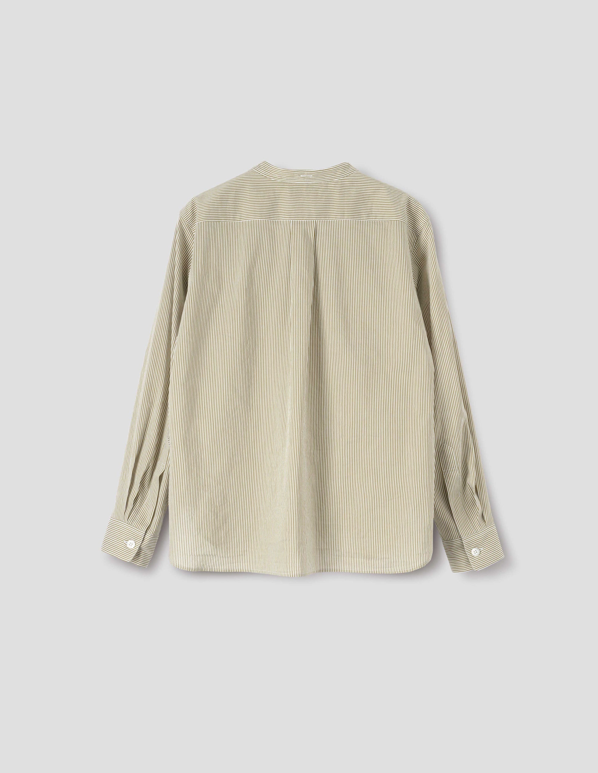 Green and white striped cotton silk collarless shirt, with box pleat on back yoke, elongated back hem, buttonhole detailing on collar band and horn button cuffs. Back flat lay view. 