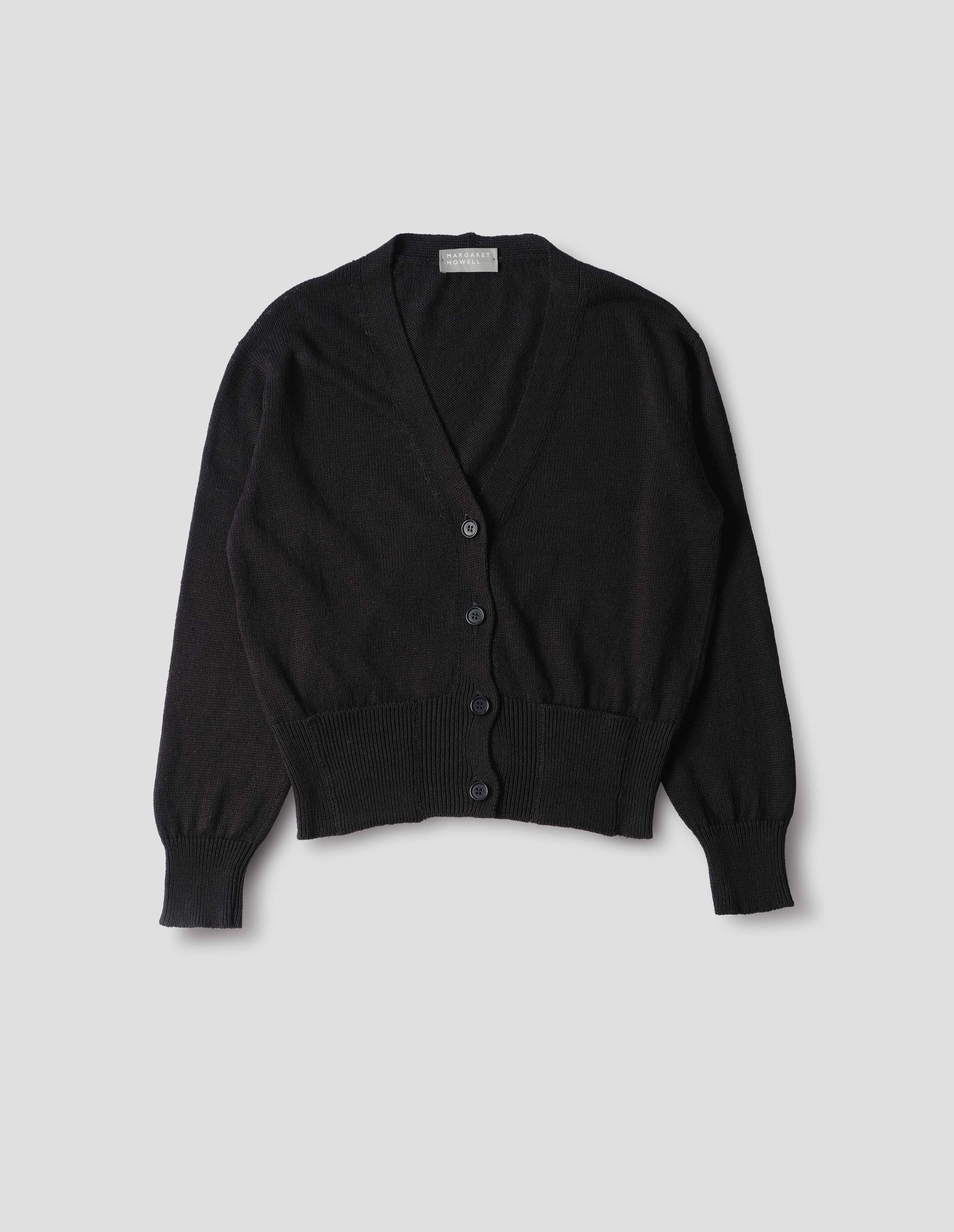Black linen cotton v neck cardigan with horn buttons, integral pockets and rib on neck, cuffs and wide hem. Front flat lay view.