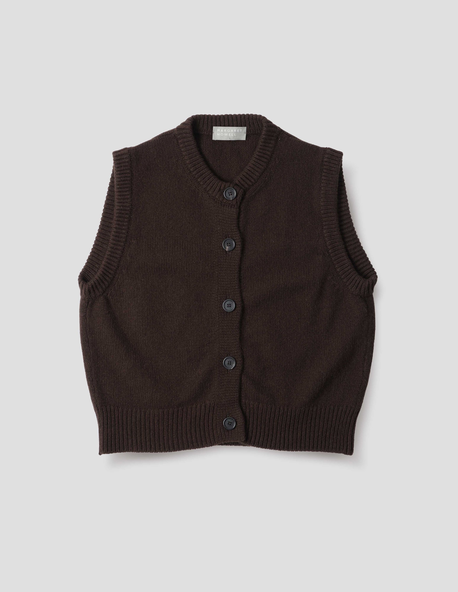 Dark brown sleeveless merino cashmere gilet with contrast rib neckline, hem and dark horn buttons.  Front flat lay view.