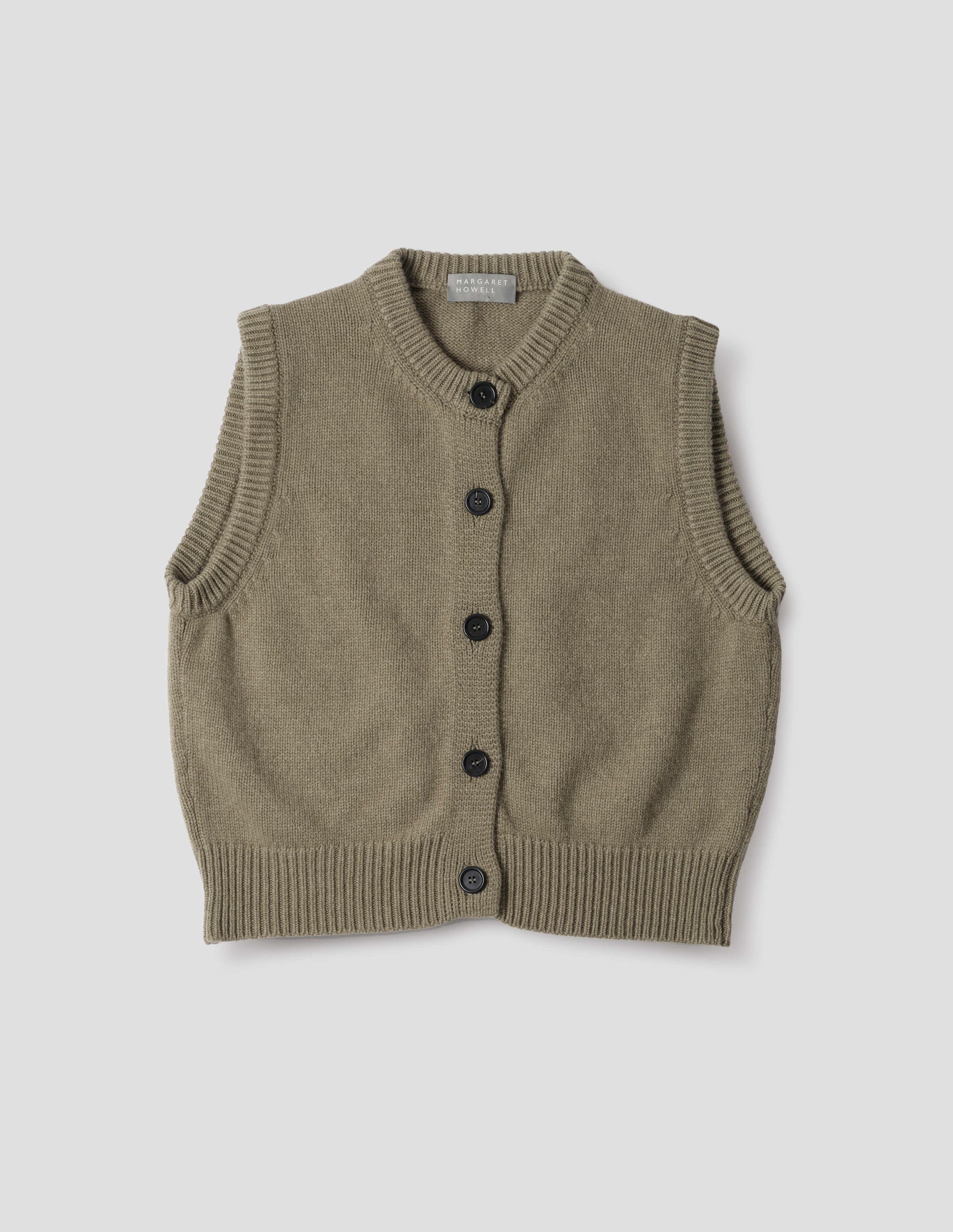 Brownish green sleeveless merino cashmere gilet with contrast rib neckline, hem and dark horn buttons.  Front flat lay view.