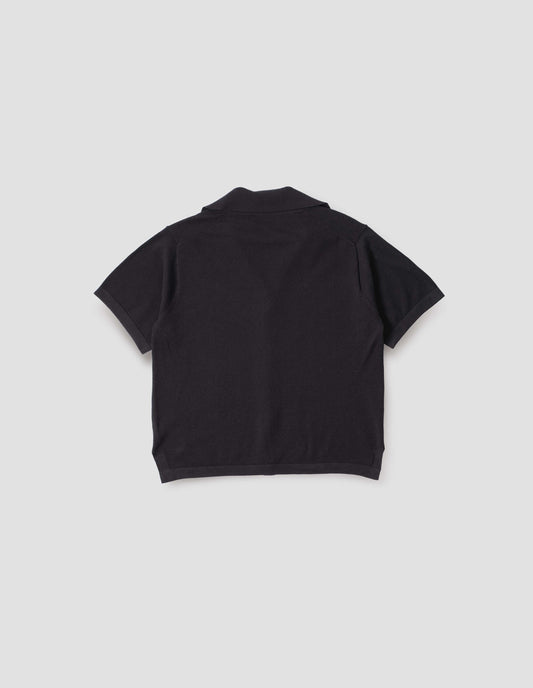 Black knitted cotton short sleeve shirt, with fine gauge rib collar, placket, cuffs and side split hem. Back flat lay view. 