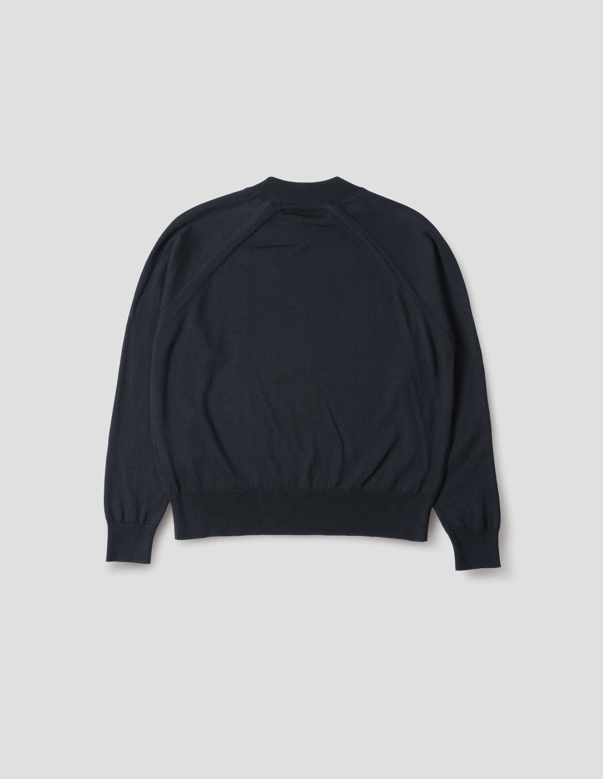 Dark navy merino wool and cotton long sleeve jumper with raglan sleeve, deep rib crew neck and single rib cuffs and hem. Back flat lay view.