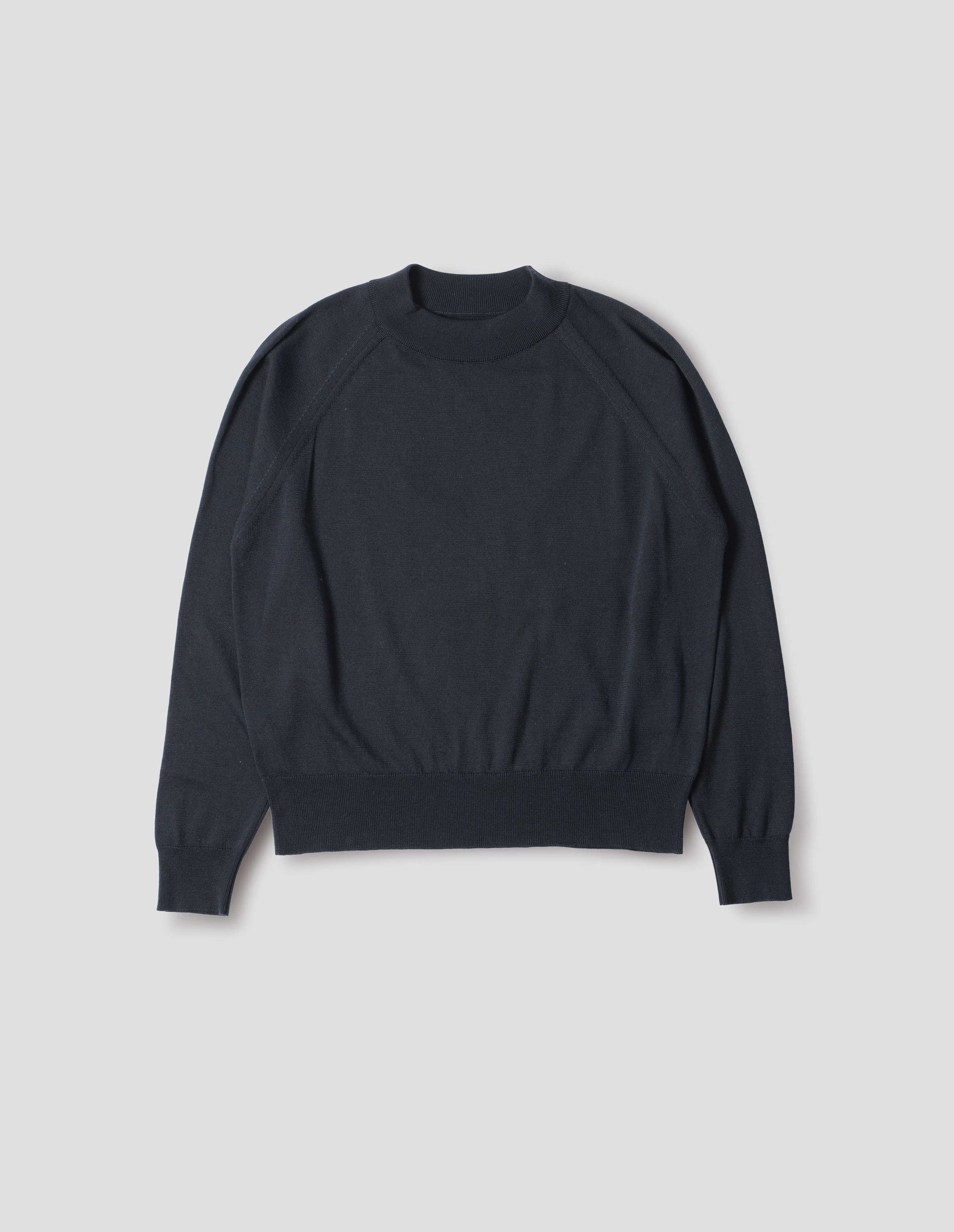 Dark navy merino wool and cotton long sleeve jumper with raglan sleeve, deep rib crew neck and single rib cuffs and hem. Front flat lay view.