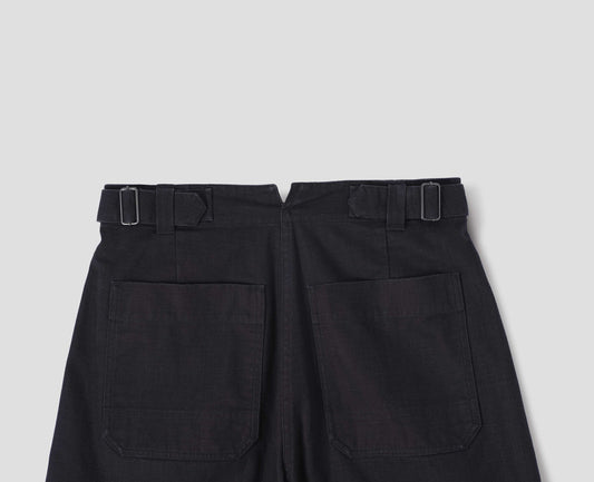 Indigo blue barrel leg trouser, with two patch pockets and silver metal waist tab adjuster. Back flat lay view. 