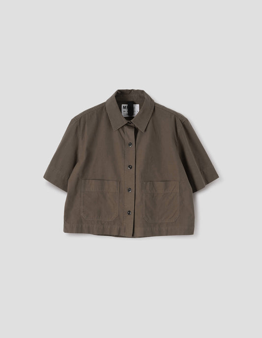 Greenish brown short sleeve cotton shirt, with raised placket, patch pockets, side split hem and horn button closure. Front flat lay view. 