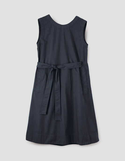 Dark navy cotton sleeveless dress with round neck, wrap around belt, side seam pockets and deep stitch hem. Front flat lay view.