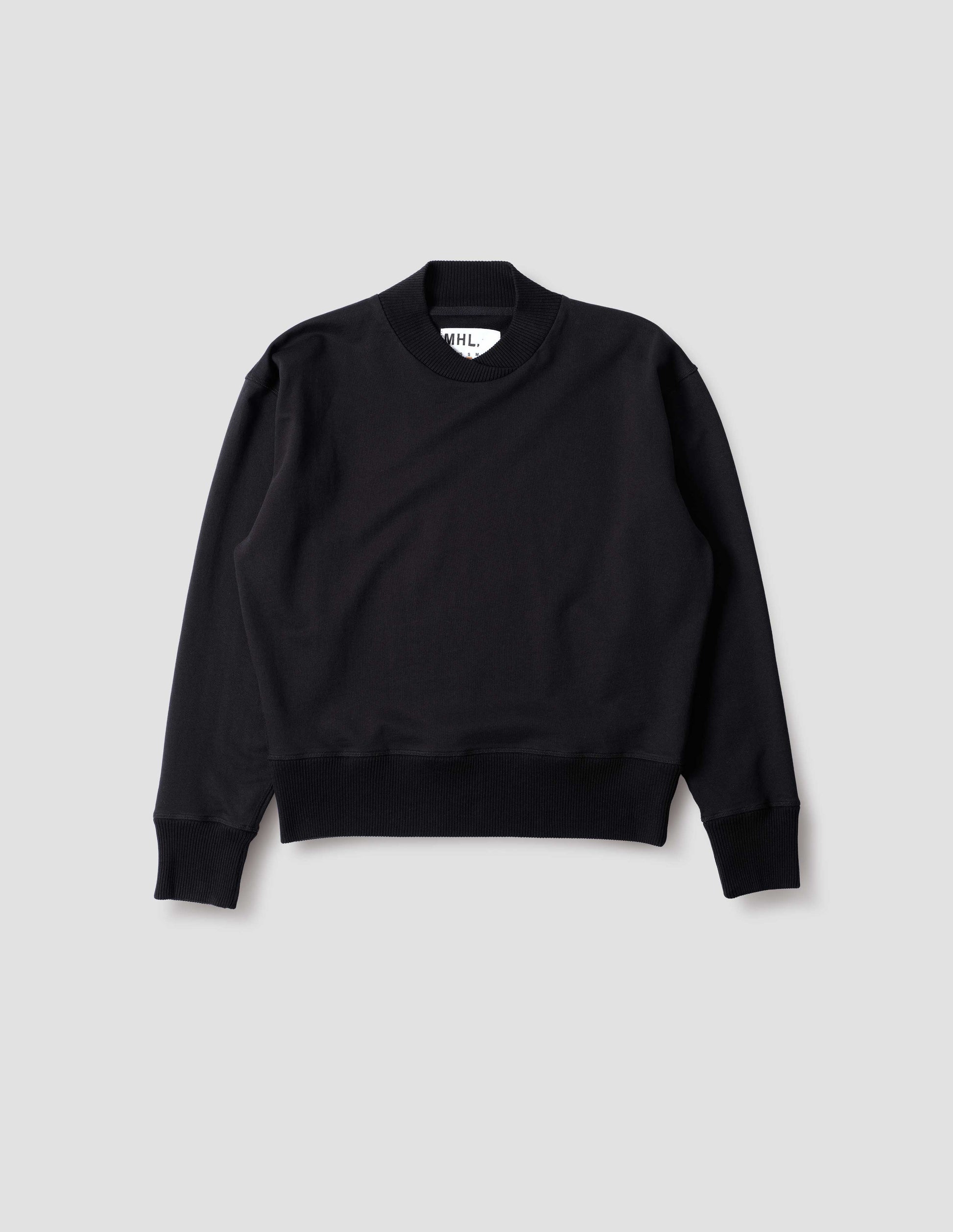 Black cotton sweatshirt, with soft rib neck with crossover detail and ribbed cuffs and hem. Front flat lay view.