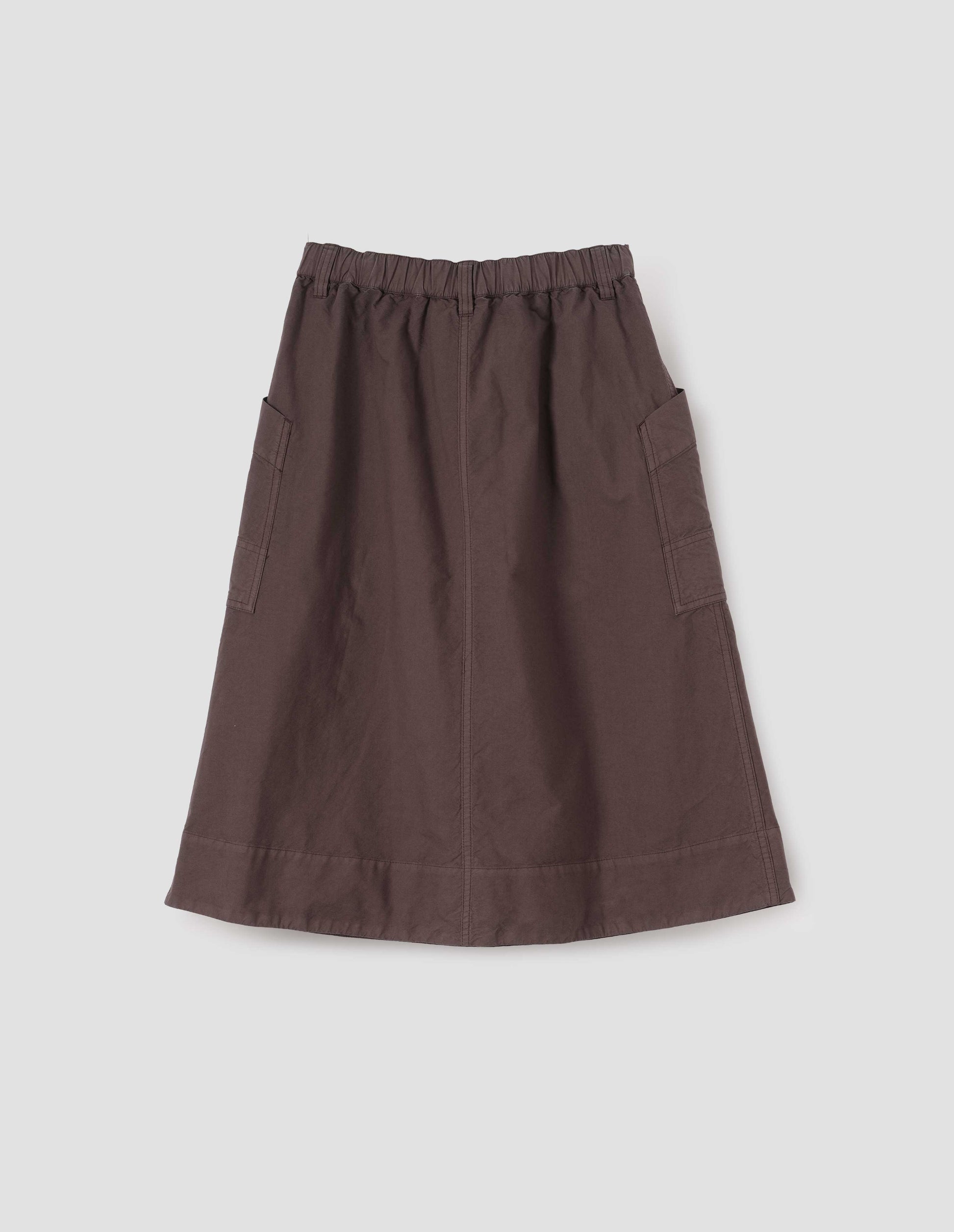 Brown cotton skirt with large slant patch pockets, elasticated waistband with belt loops and deep stitch hem. Back flat lay view. 