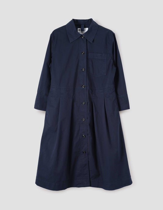 Dark blue cotton pleated shirt dress, with patch pocket on chest, corozo button fastening, pleats on seam from waist down and hanger loop on inside collar. Front flat lay view.