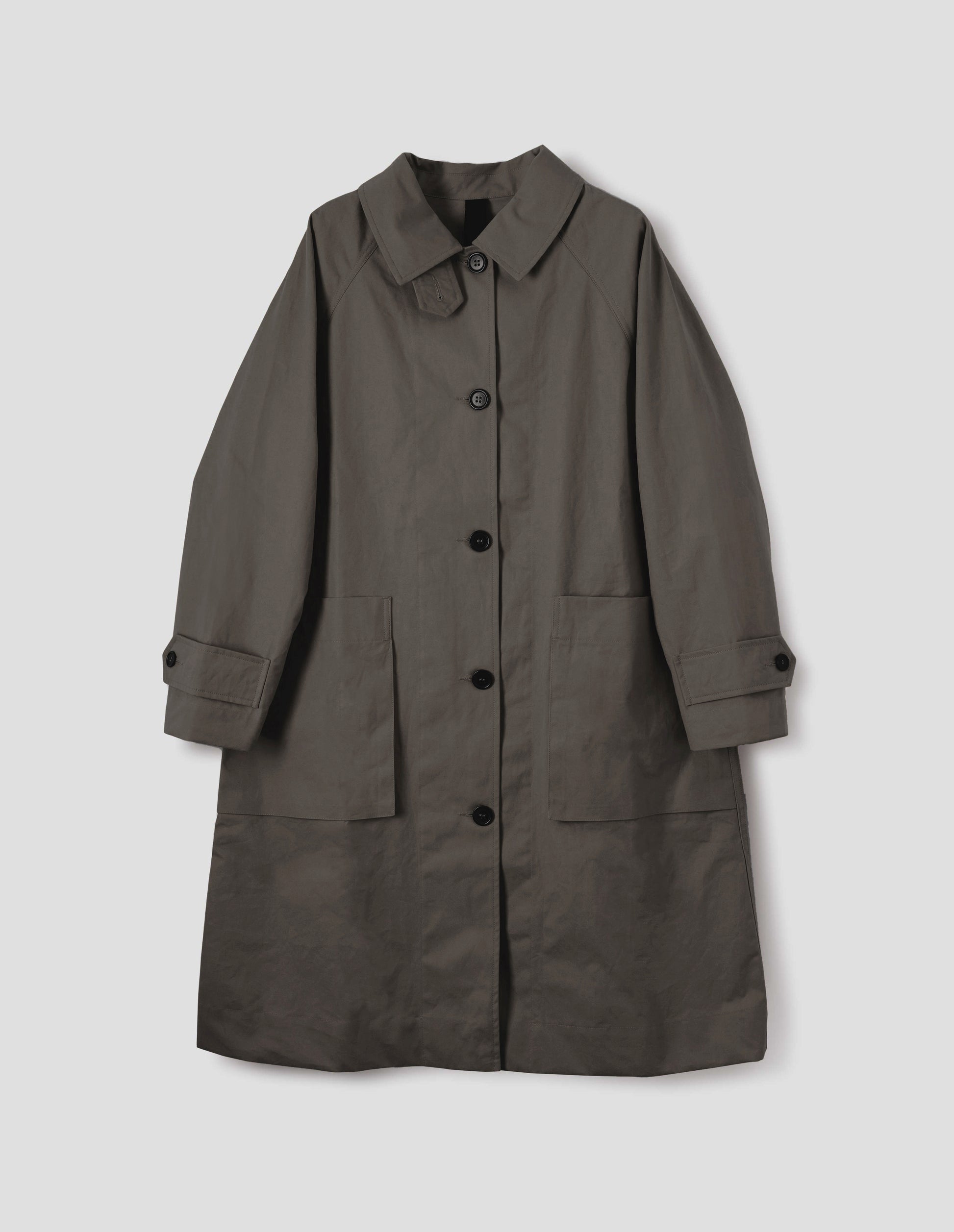 Greyish brown cotton canvas long sleeve mac, with storm tab fastening neck, raglan sleeve, button tab adjustable cuffs and large patch bellow pockets. Front flat lay view.