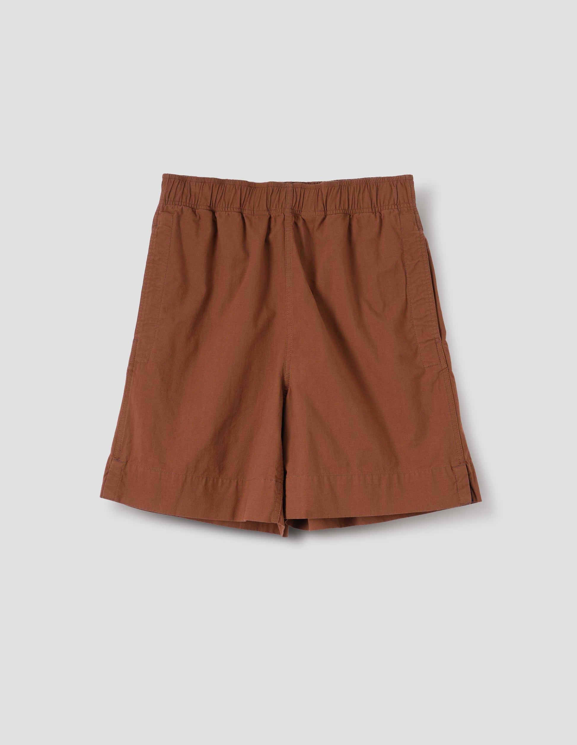 Dark orange shorts with elasticated waist, side pockets and side split hem. Front flat lay view.