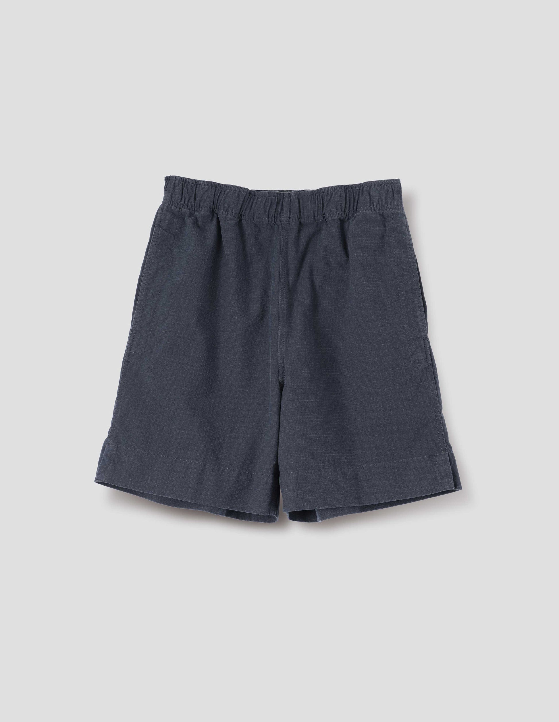 Dark navy blue cotton shorts with elasticated waist, concealed side pockets, herringbone tape drawcord and side split hem. Front flay lay view.