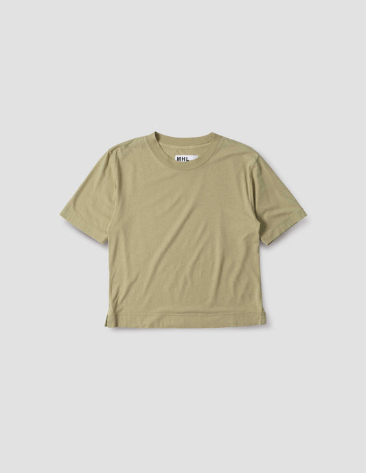 Pale green cotton linen short sleeve t-shirt with herringbone tape detailing on inside neck and vent split hem. Front flat lay view.