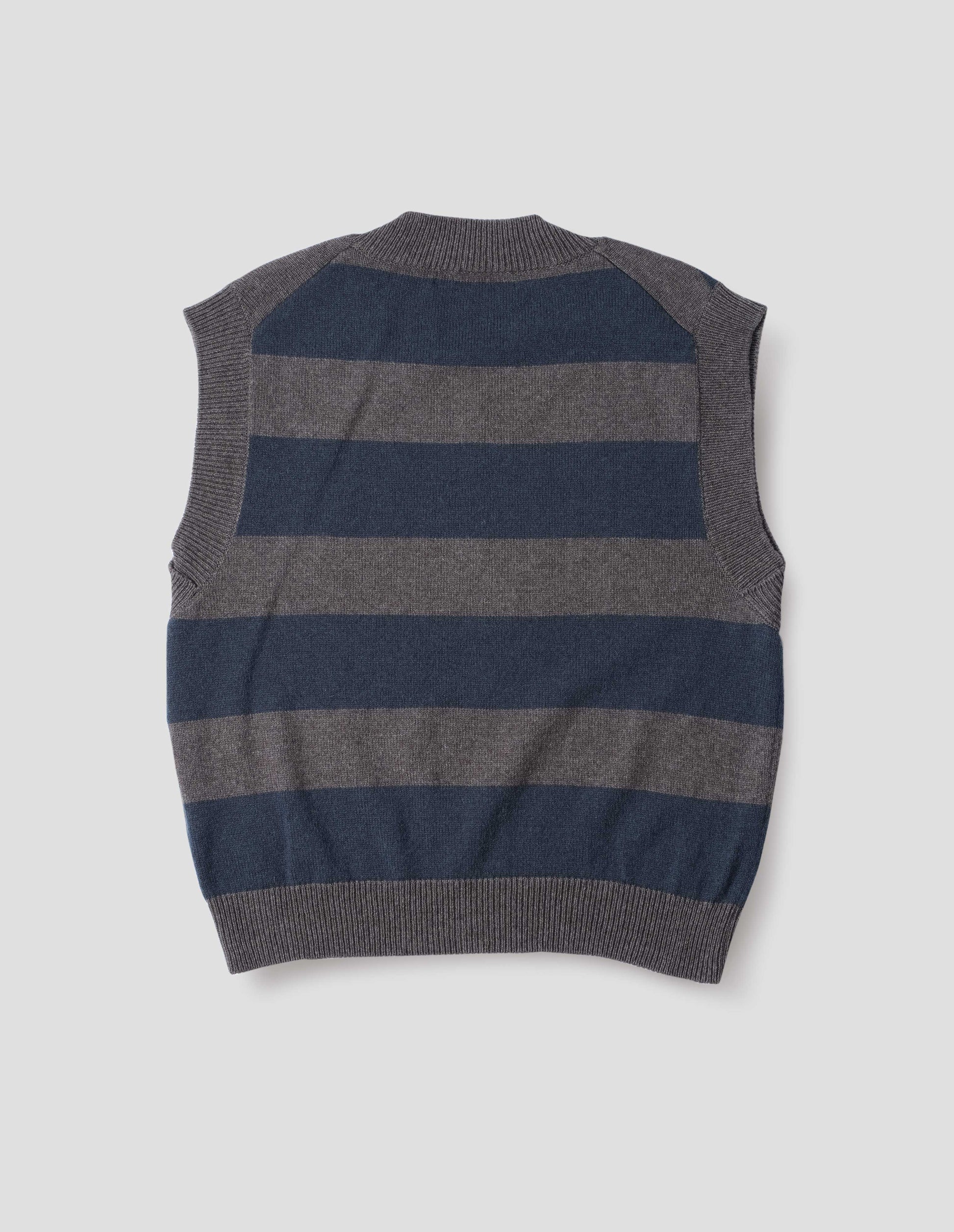 Grey and dark navy striped v neck slipover, with contrast rib v neck, armholes and hem. Back flat lay view.
