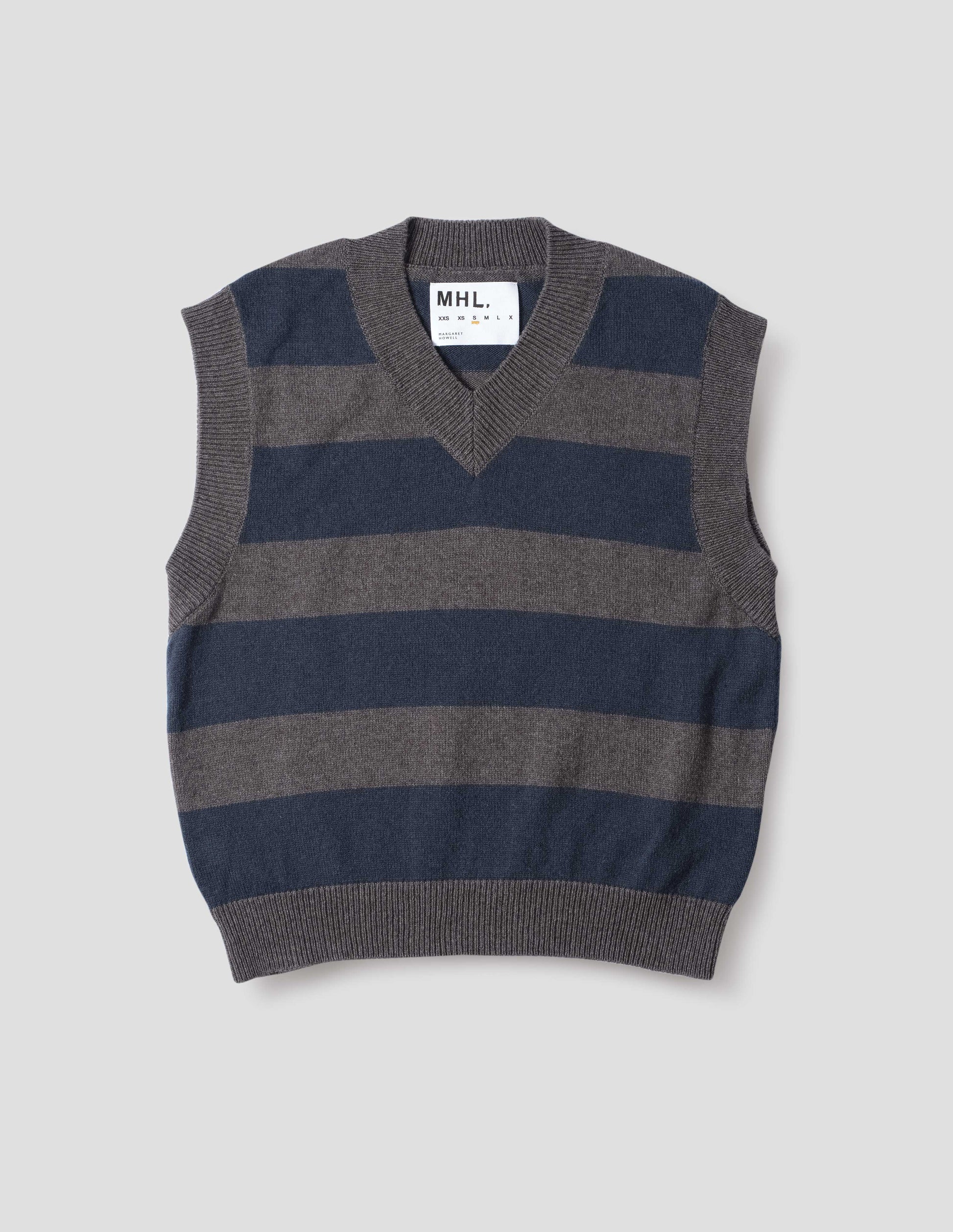 Grey and dark navy striped v neck slipover, with contrast rib v neck, armholes and hem. Front flat lay view.