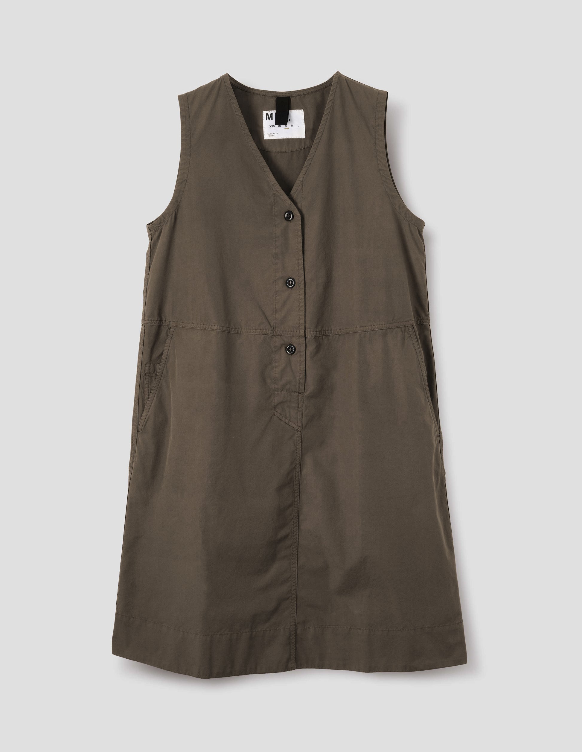 Greenish brown sleeveless dress with v neck detailing, slant side pockets and corozo brace button closure. Front flat lay view. 
