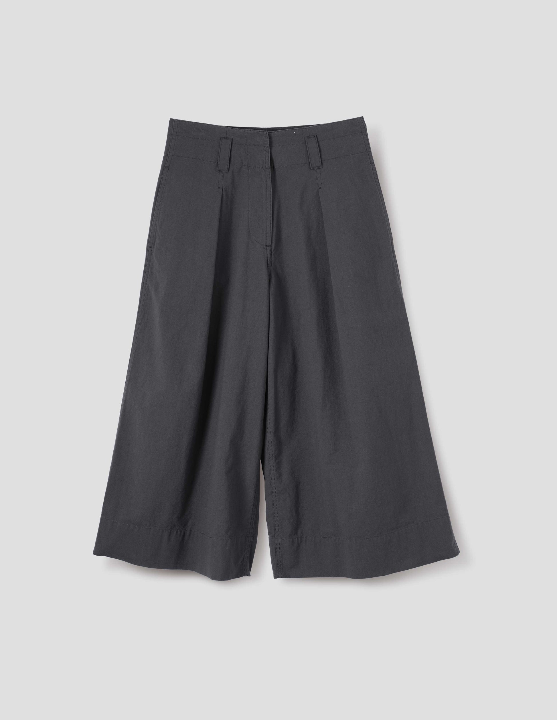 Grey culottes with zip fly, stitch-through waistband with dropped belt loops, bar tacked pleats, concealed wide pockets and deep stitch-through hem. Front flat lay view.