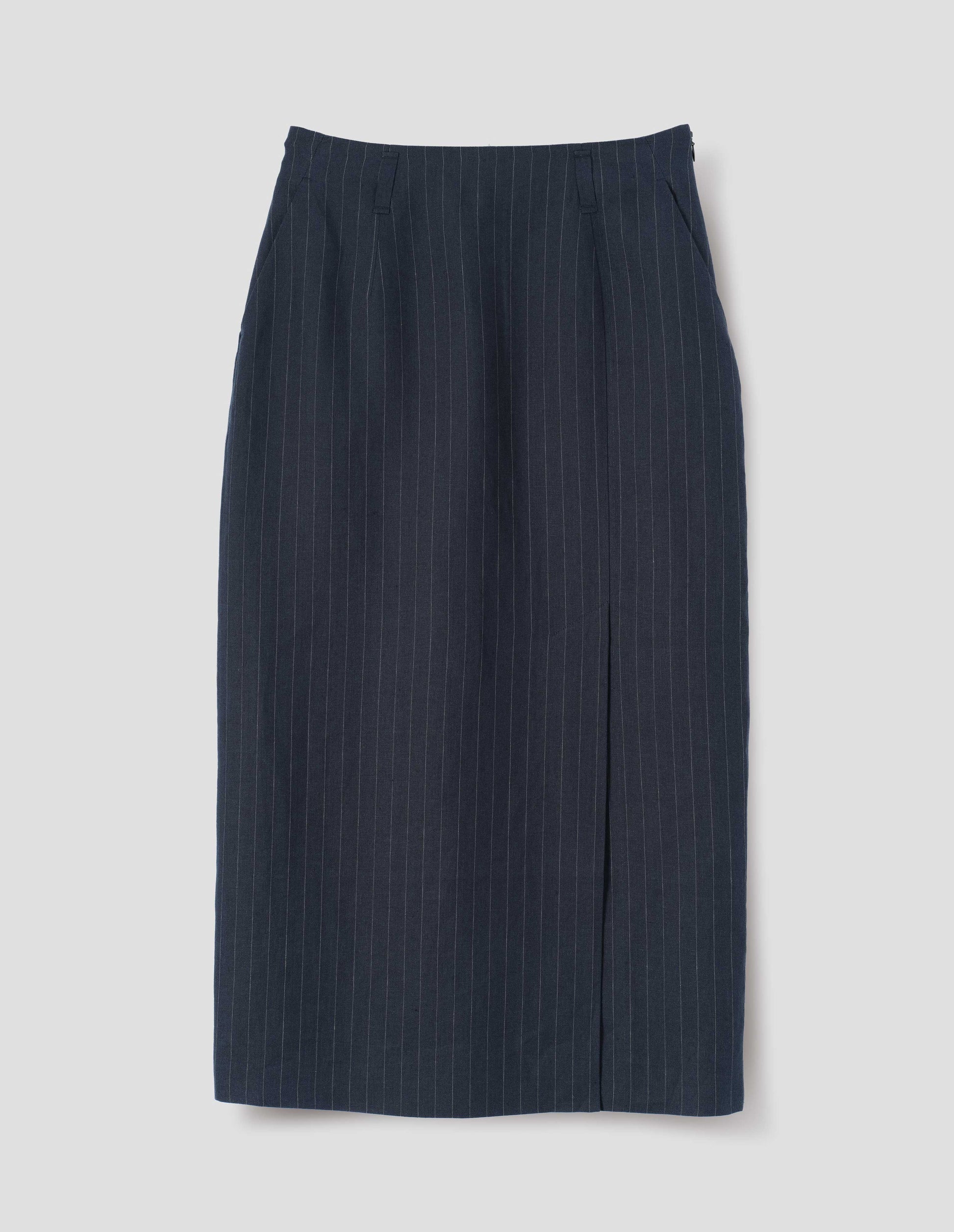 Navy and grey pinstripe linen skirt, with offset front vent, concealed side zip fastening, slant side pockets and belt loops. Front flat lay view.