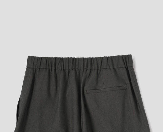 Brownish green linen silk trousers, with half elasticated waistband and belt back pocket. Back flat lay view.